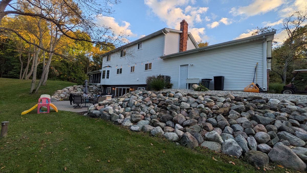 Back corner of the house above a long boulder retaining wall