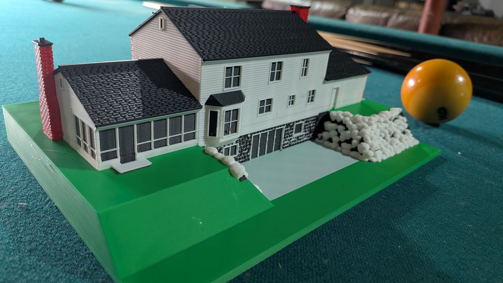 The mini from the porch end: the screened porch, the brick chimney, and the printed boulders