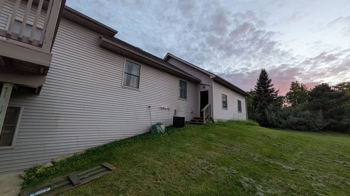Back wall of the house at dusk, with the back door and steps